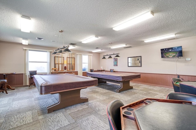 game room with pool table, wooden walls, light colored carpet, and a textured ceiling