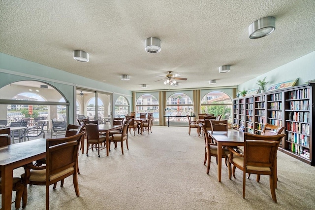 dining area featuring light carpet and ceiling fan