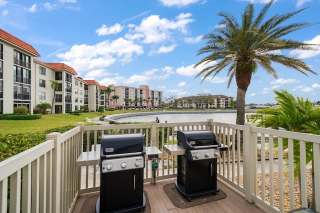 deck with a water view and area for grilling