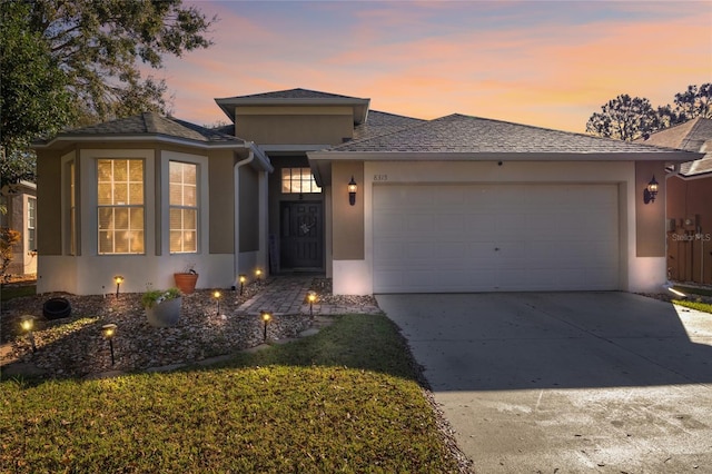 view of front of property with a garage, driveway, and stucco siding