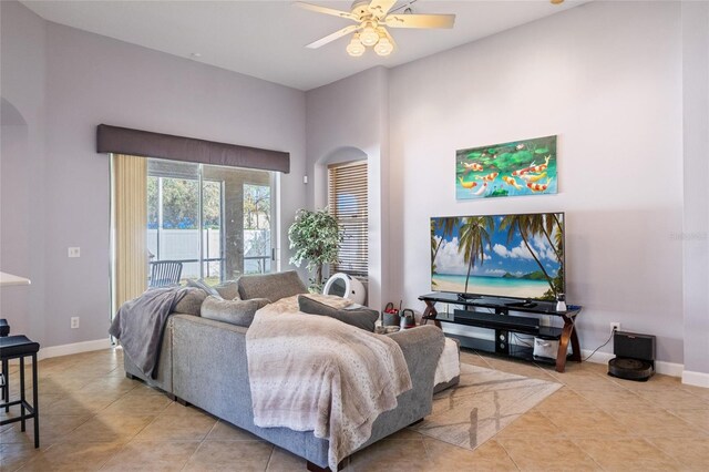 tiled bedroom featuring baseboards, arched walkways, a towering ceiling, ceiling fan, and access to outside