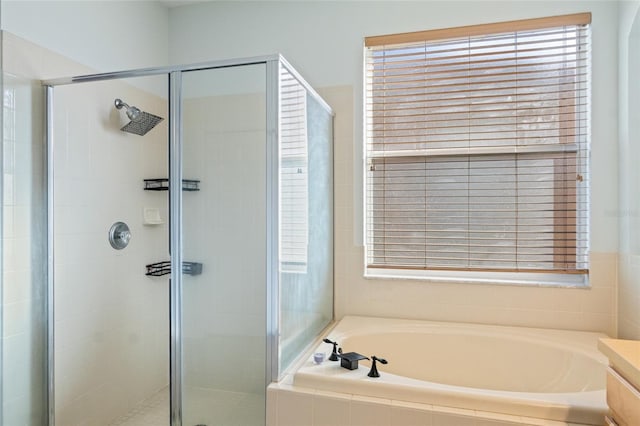 bathroom featuring a shower stall and a bath