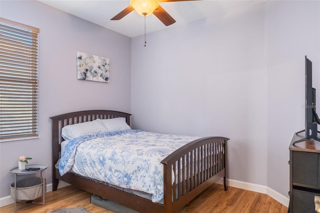 bedroom with ceiling fan, baseboards, and wood finished floors