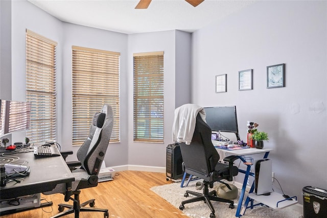 home office featuring ceiling fan, light wood finished floors, and baseboards