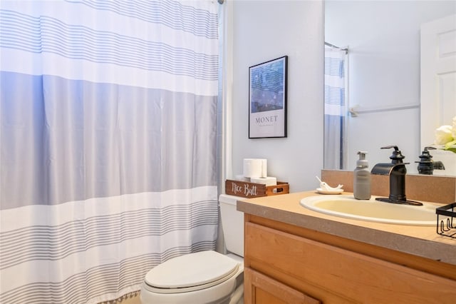 bathroom with curtained shower, vanity, and toilet