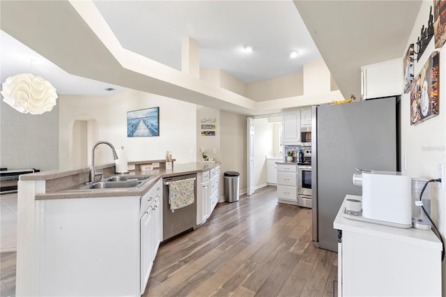 kitchen with stainless steel appliances, sink, wood-type flooring, and white cabinets