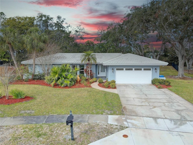 single story home with a garage and a yard