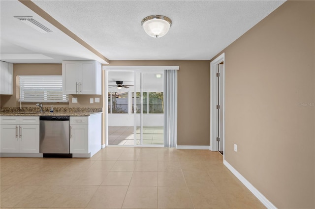 kitchen featuring white cabinetry, stainless steel dishwasher, a textured ceiling, and light stone counters