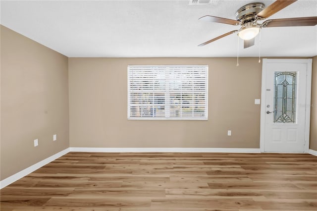 foyer entrance featuring a textured ceiling, ceiling fan, and light wood-type flooring