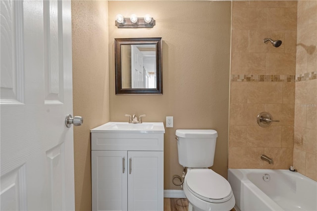 full bathroom with vanity, tiled shower / bath combo, and toilet