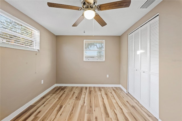 unfurnished bedroom with ceiling fan, a closet, and light wood-type flooring