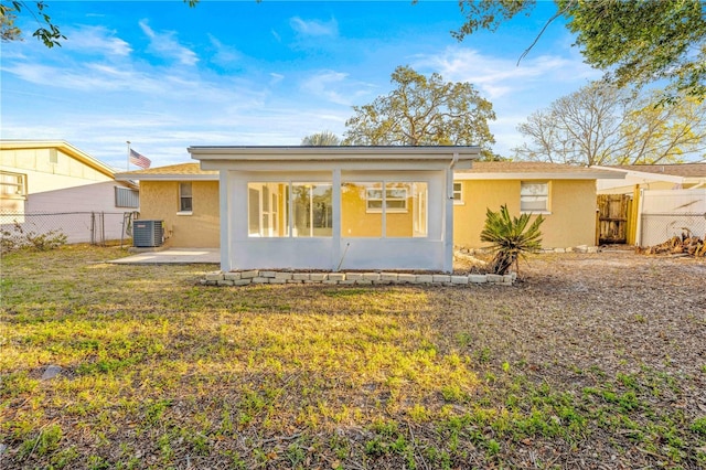 back of house with a patio area, central air condition unit, and a lawn