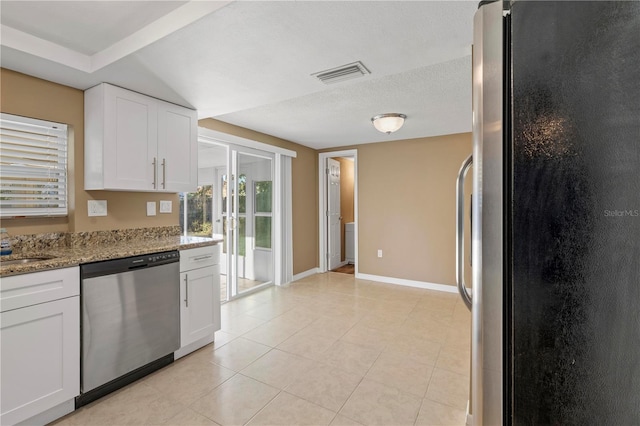 kitchen featuring appliances with stainless steel finishes, white cabinetry, light stone countertops, a textured ceiling, and light tile patterned flooring