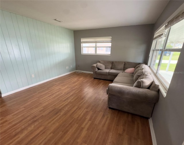 living room with a healthy amount of sunlight and dark hardwood / wood-style flooring