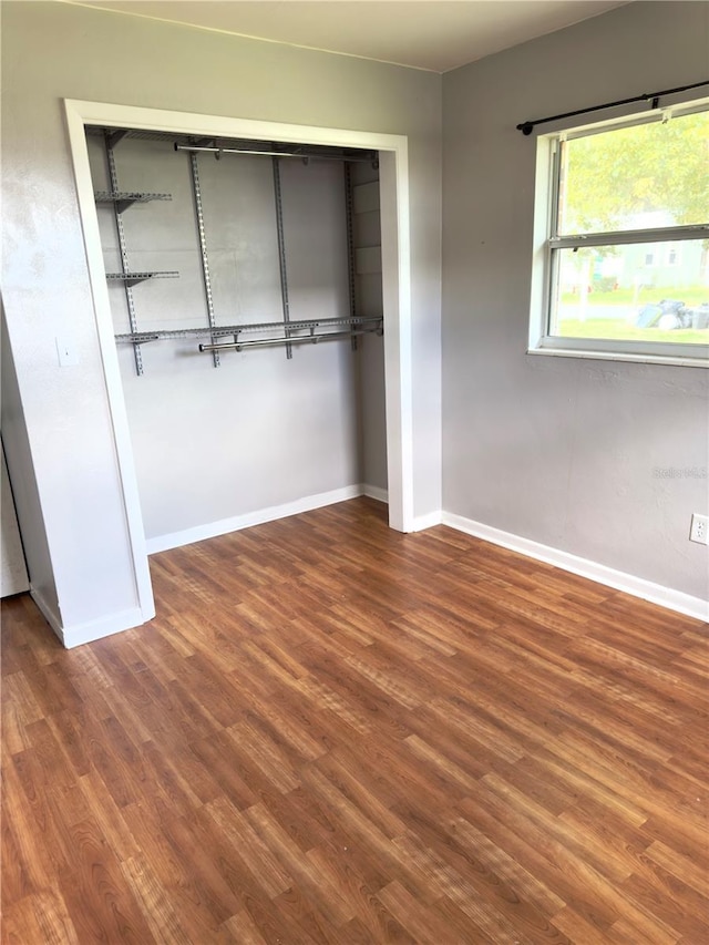 unfurnished bedroom with wood-type flooring and a closet