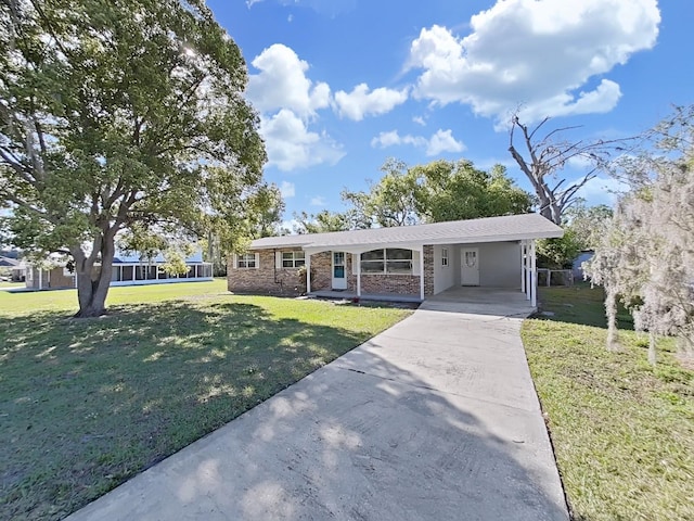 ranch-style house featuring driveway, a carport, and a front lawn