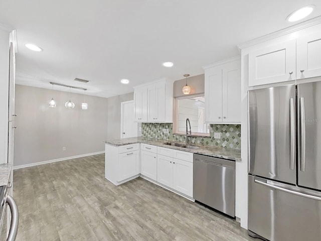 kitchen with visible vents, a sink, stainless steel appliances, white cabinetry, and tasteful backsplash