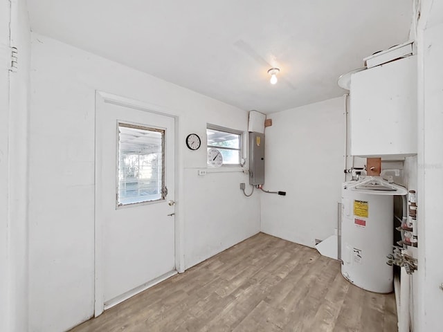 utility room featuring electric panel and electric water heater