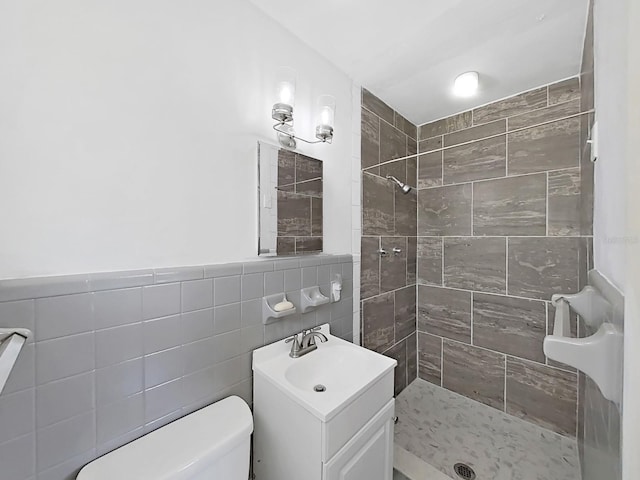 bathroom featuring vanity, toilet, tile walls, and a shower stall