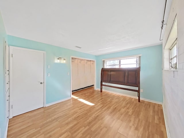 foyer featuring light wood finished floors, visible vents, and baseboards