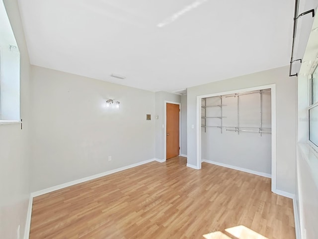 unfurnished bedroom with a closet, light wood-type flooring, and baseboards