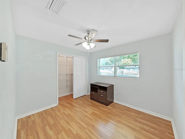 unfurnished bedroom with a closet, visible vents, light wood-style flooring, and baseboards