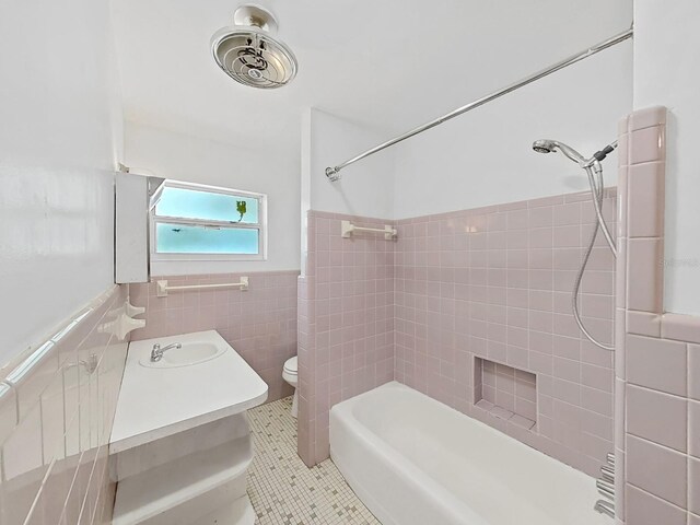 bathroom featuring tile patterned floors, toilet, tile walls, wainscoting, and vanity