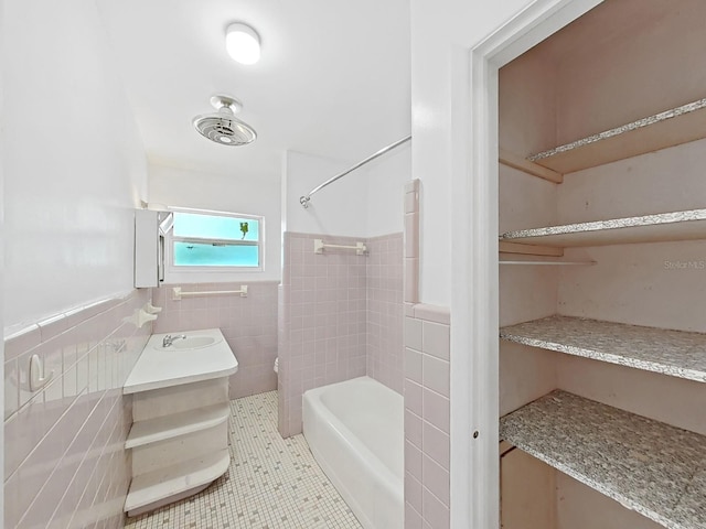 bathroom with wainscoting, shower / washtub combination, tile walls, toilet, and tile patterned floors