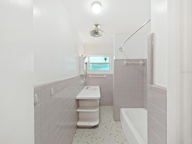 full bath with a sink, a wainscoted wall, tile walls, and tile patterned flooring