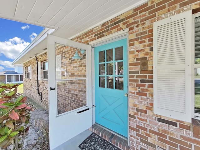 property entrance featuring brick siding