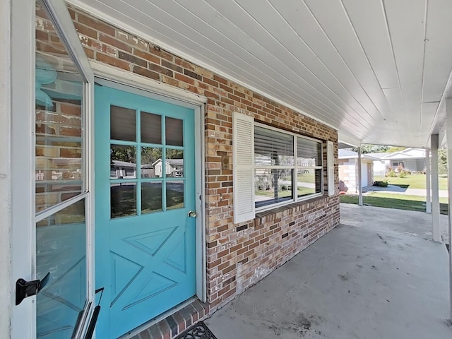 view of exterior entry featuring brick siding