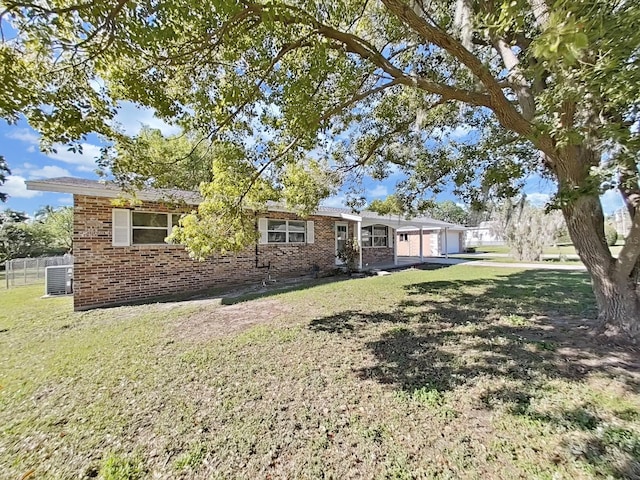 view of front of house featuring brick siding, a front yard, a garage, and fence