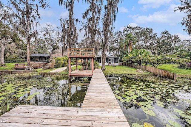 dock area with a yard, fence, and a wooden deck