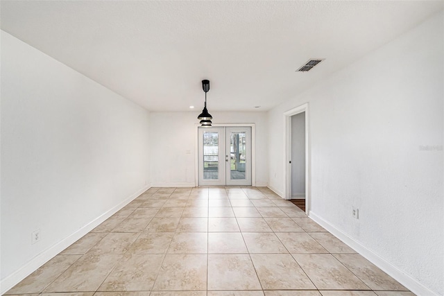 spare room with light tile patterned floors, french doors, visible vents, and baseboards