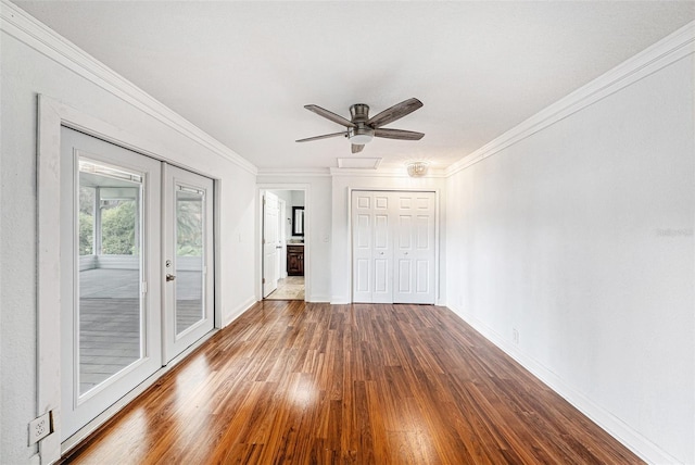 unfurnished room with crown molding, baseboards, ceiling fan, and wood finished floors