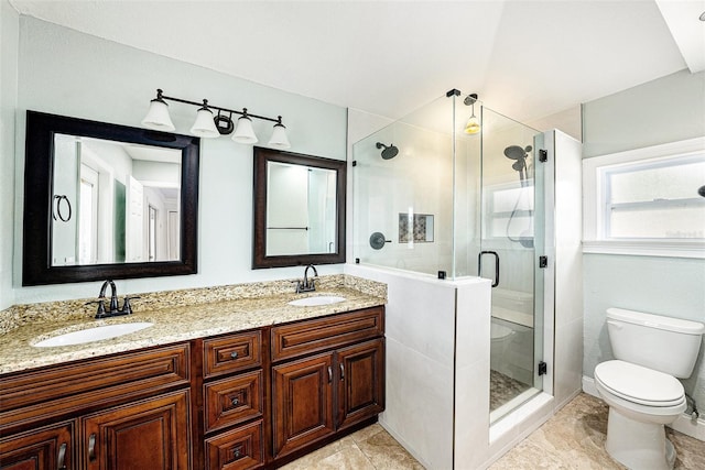 full bathroom with toilet, a shower stall, double vanity, and a sink