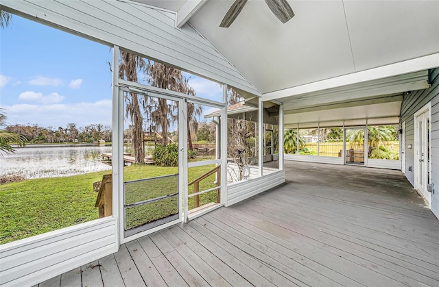 unfurnished sunroom featuring a water view, lofted ceiling with beams, and a ceiling fan