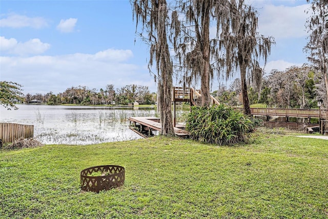 dock area with a water view and a yard