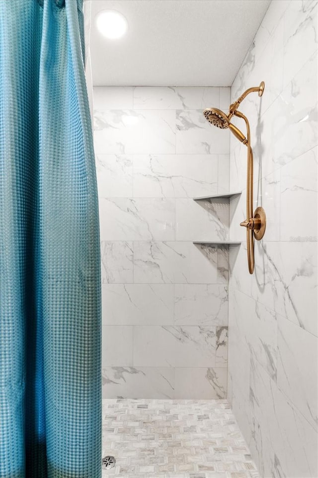 bathroom with a shower with shower curtain and a textured ceiling