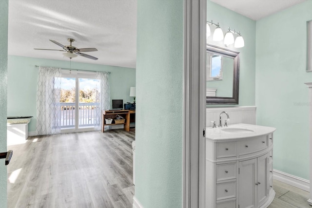 bathroom featuring vanity, hardwood / wood-style floors, a textured ceiling, and ceiling fan