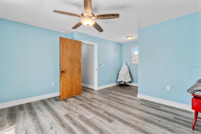 spare room featuring a textured ceiling, light hardwood / wood-style floors, and ceiling fan