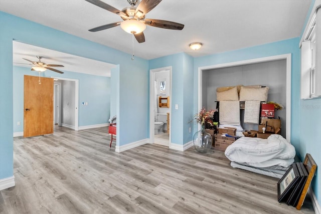 interior space featuring ceiling fan, ensuite bathroom, and light hardwood / wood-style floors