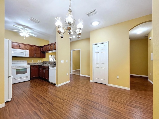 kitchen with sink, hanging light fixtures, dark hardwood / wood-style flooring, white appliances, and ceiling fan with notable chandelier