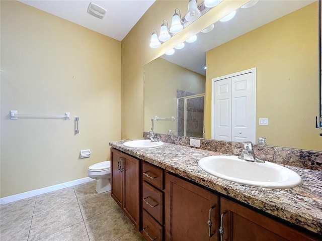 bathroom with vanity, tile patterned flooring, toilet, and walk in shower