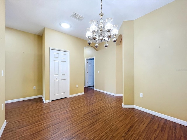 unfurnished room featuring dark hardwood / wood-style floors and a chandelier