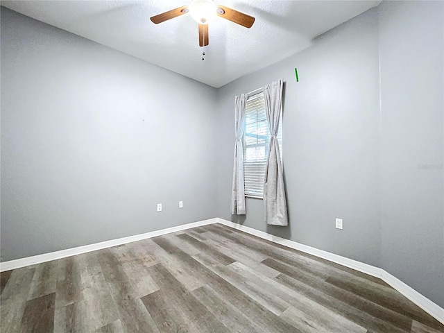 empty room with wood-type flooring, ceiling fan, and a textured ceiling