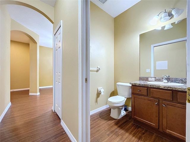 bathroom with vanity, wood-type flooring, and toilet