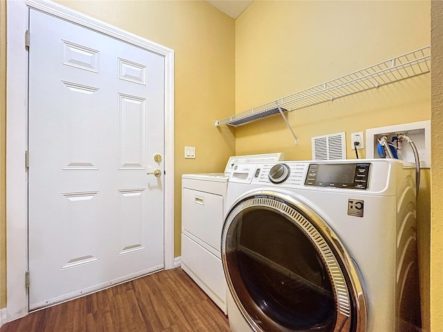 laundry room with hardwood / wood-style floors and washing machine and dryer