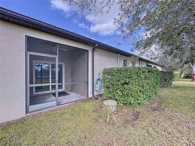 view of side of property featuring a sunroom and a yard