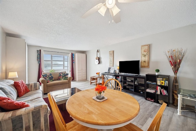 dining area featuring ceiling fan, a textured ceiling, and light wood-type flooring